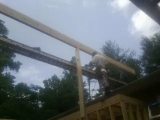 Carpenter setting a ridge beam over a new addition frame — Ice Dam Removal by Roofing Brothers in Terra Ceia