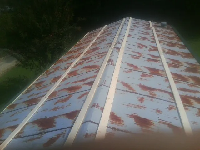 Rusted metal roof panels with new wood purlins before replacement — Storm Damage Roof Repair in Terra Ceia by Roofing Brothers