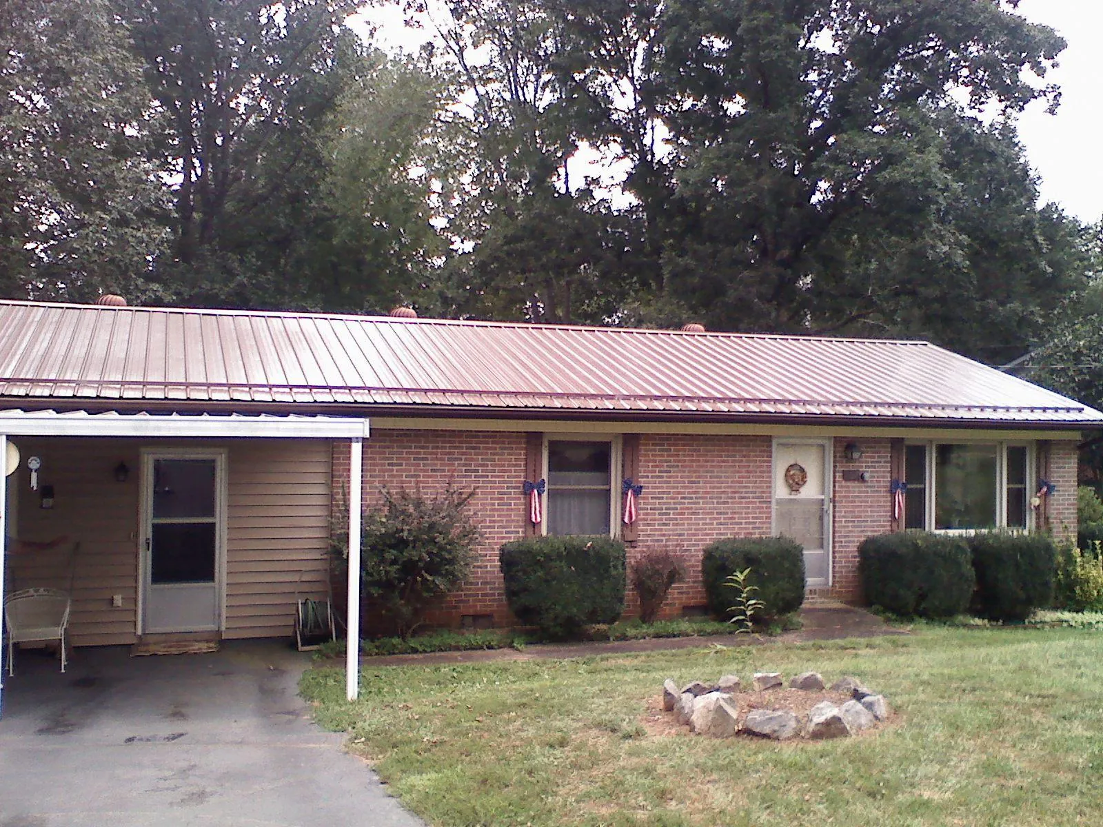 Bronze metal roof and carport on a brick ranch home — Roof Repair work by our crew in Terra Ceia
